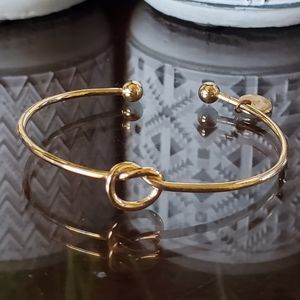 Gold knotted heart bracelet with letter "T"